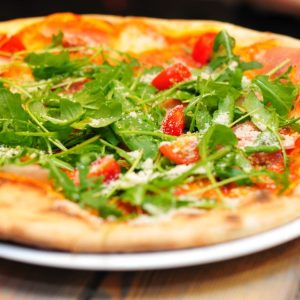 Pizza Rusticana mit Rucola und Parmesan - Pizzeria Bella